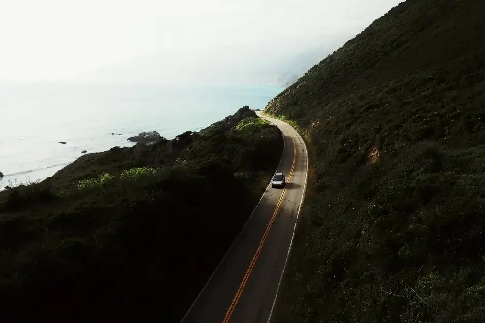 Aerial view of the Pacific Coast Highway winding along the Big Sur cliffs