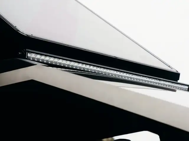 Close-up of the Cybertruck light bar and stainless hood edge